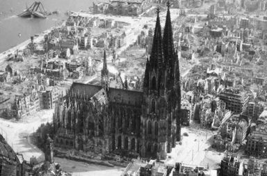 The Cologne Cathedral stands tall amidst the ruins of the city after allied bombings, 1944