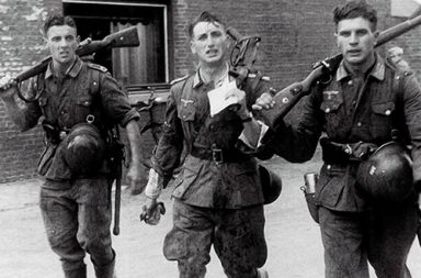 Three German soldiers returning from training exercise, France, October 1941.