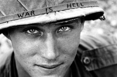 An American soldier wears a hand lettered War Is Hell slogan on his helmet, Vietnam, 1965